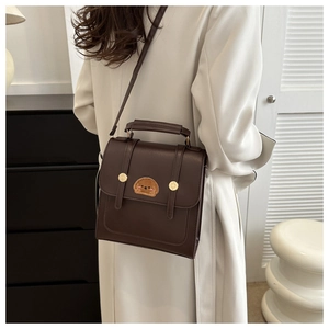 Detail of dark brown retro PU leather bag featuring a cute dog embroidery patch and handle
