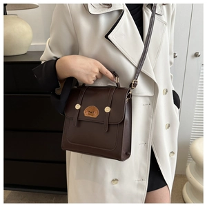Brown vintage leather crossbody bag with cute puppy embroidery on a female model