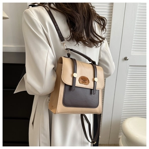 Retro color-block backpack with flap buckles and cute bear patch shown on a model