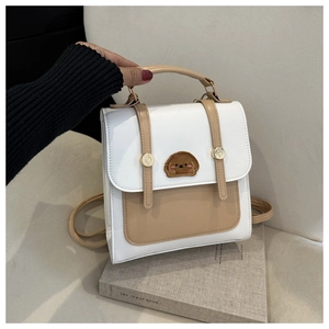 Close-up of minimalist mini backpack featuring puppy patch and golden metal studs