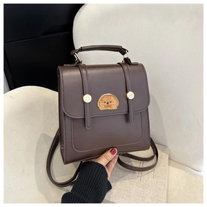 Detail of dark brown retro square backpack with cute dog embroidery and gold hardware