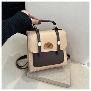 Detail of retro contrast color backpack with cute dog patch and golden metal hardware