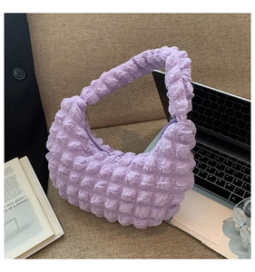 Dettaglio della trama a bolle viola su una borsa hobo a pieghe dal design minimal