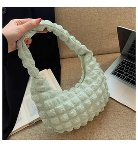 Dettaglio borsa a nuvola verde menta con texture a bolle e chiusura a zip robusta