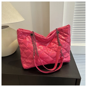 Close-up of fuchsia quilted tote bag featuring glossy PU leather and metal chain strap