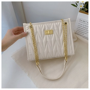 Detail of off-white quilted shoulder bag featuring gold twist lock and chain strap