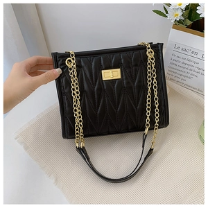 Close-up of black quilted chain shoulder bag with gold turn-lock and wavy stitching