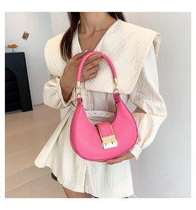 Detail of a bright pink half-moon handbag featuring a gold square metal clasp
