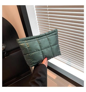 Detailaufnahme einer dunkelgrünen gesteppten Nylon-Clutch mit glänzendem Finish