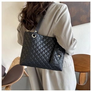 Detail einer schwarzen gesteppten Tote Bag mit abnehmbarer kleiner Tasche an der Schulter