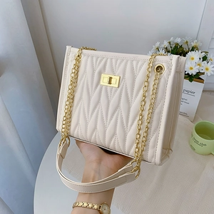 Chic beige quilted shoulder bag with gold chain strap and secure twist lock closure