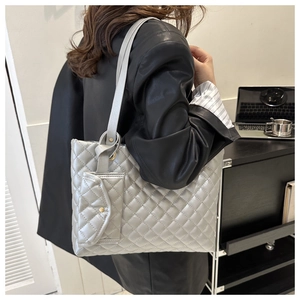 Nahaufnahme der silbernen Stepptasche in der Seitenansicht an der Schulter des Models