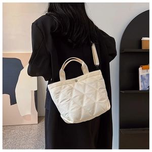 Détail du sac seau matelassé blanc montrant les coutures précises et la bandoulière large