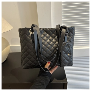 Makroaufnahme der Rautensteppung und Minitasche an der schwarzen Shopper-Bag