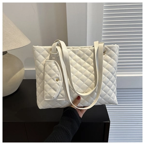 Detail der weißen gesteppten Tragetasche mit Rautenmuster und kleiner Zusatztasche