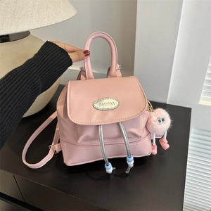 Pink mini PU leather backpack with plush charm and polished metal flip cover plate