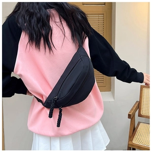 Detail der minimalistischen schwarzen Nylon-Brusttasche mit geflochtenem Reißverschluss
