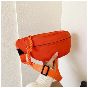 Detailaufnahme der hellorangen Brusttasche mit gewebtem Reißverschluss und verstellbarem Gurt