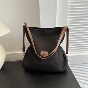 Minimalist large capacity black tote bag with brown leather straps for daily commute