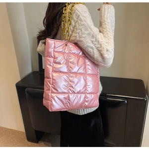 Detail shot of the pink quilted bucket bag with a glossy finish and chunky gold chain strap