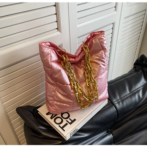 Detailed view of pink quilted tote bag with chunky gold chain strap and padded texture