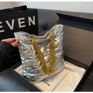 Detail of silver quilted bucket bag with large gold chain strap and padded texture