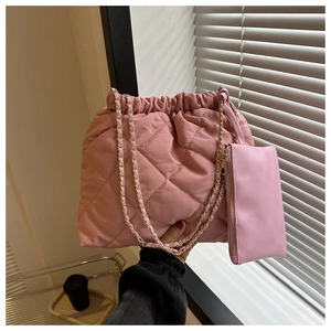 Detail van roze gewatteerde puffer bucket bag met kettingriem en klein ritszakje