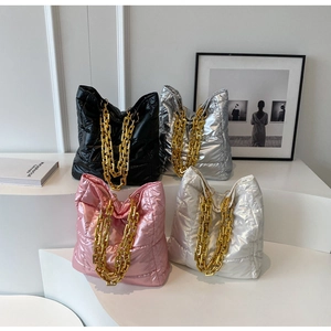 Quilted tote bags in black, silver, pink, and white with chunky gold chains detail