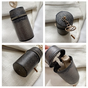Detail of mini black translucent cylindrical pouch showing zipper and lobster clasp