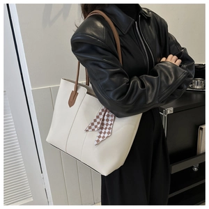 Detail der cremeweißen Ledershopper mit braunem Trageriemen und kariertem Seidenschal