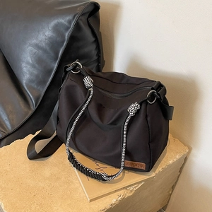 Large black nylon tote bag with zigzag woven handle and adjustable wide strap