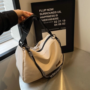 Cream white nylon tote bag with adjustable shoulder strap and woven rope detail