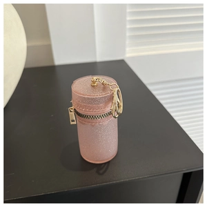 Detailed macro view of pink glitter cylindrical coin purse with gold zipper and lobster clasp