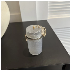 Detailed close-up of a mini cylindrical glitter bag with gold hardware and zipper