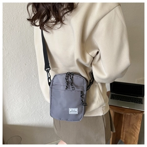 Detailed side view of a gray Oxford fabric crossbody bag with adjustable black strap
