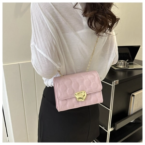 Borsa a tracolla rosa trapuntata con fibbia dorata abbinata a gonna nera e top bianco