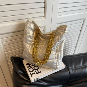 Silver quilted padded bucket bag with thick gold chain handle for modern stylish women