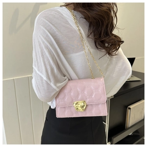 Vista posteriore dettagliata di una borsa rosa trapuntata con catena dorata sul modello