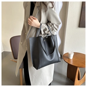 Detail of minimalist black tote bag with vertical stitching for elegant daily commute