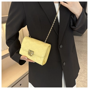 Dettaglio borsa a tracolla giallo chiaro con texture geometrica e catena dorata