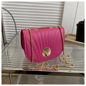 Detail of rose red saddle bag with shell stitching and gold metal twist lock buckle