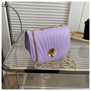 Detailed view of lavender saddle bag with shell clasp and gold bead chain strap