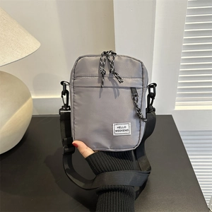 Borsa a tracolla in nylon oxford grigio con tracolla regolabile e patch Hello Weekend