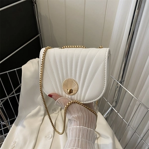 Elegant white leather crossbody bag with shell lock and gold chain strap in minimalist style
