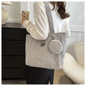 Detail of light gray corduroy tote bag with round coin purse and fashion brand label