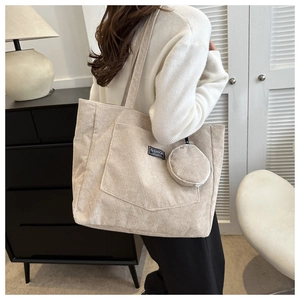 Detail of cream corduroy tote bag featuring front pocket and circular pouch attachment