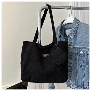 Detail of black corduroy tote bag with FASHION patch and matching coin purse charm