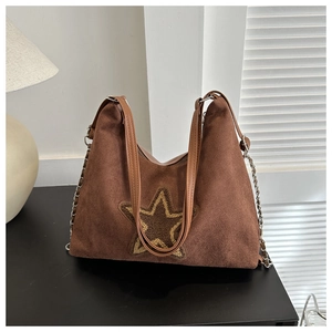 Vue détaillée du sac hobo en daim café avec écusson étoile et chaîne métallique