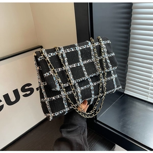 Detailopname van de geruite tweed handtas met een klassieke metalen kettingriem