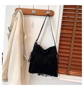 Detail einer schwarzen Wildleder-Schultertasche mit dreistufigen Fransen im Boho-Stil